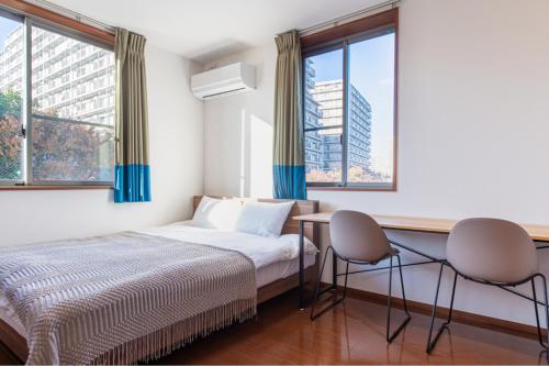 东京Residencial Voyan 南砂町的一间卧室配有一张床、两把椅子和窗户