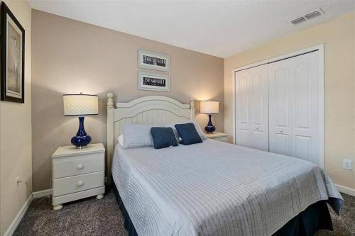 基西米Lovely new Townhome paradise的一间卧室配有一张带蓝色枕头的床和两盏灯。