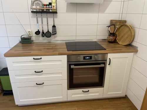 PlaueFerienwohnung Kleinbreitenbach的厨房配有白色橱柜和炉灶烤箱。