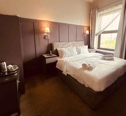 尚克林昆西米德酒店的一间卧室配有一张大床,上面有两张拖鞋