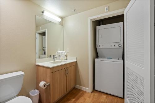 圣何塞Global Luxury Suites San Jose Downtown的一间带水槽、卫生间和镜子的浴室