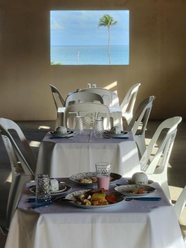 帕拉库鲁Pousada Viva Praia的上面有盘子的白色桌子