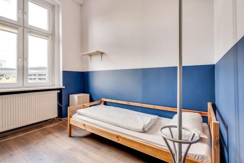 卡托维兹Hostel Kattowitz的蓝色墙壁间的一张床位