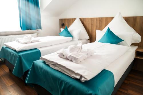 斯图加特Hotel Hansa Stuttgart City的两张位于酒店客房的床,配有蓝色枕头