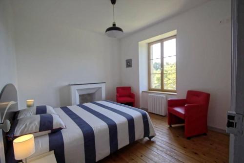 布雷Villa : Les Embruns classé 4 étoiles的一间卧室配有一张床和两张红色椅子