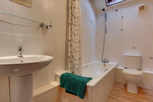 科尔切斯特Birds Farm的浴室配有盥洗盆、卫生间和浴缸。