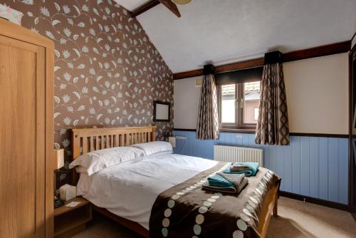 科尔切斯特Birds Farm的一间卧室配有一张带鸟图案墙壁的床