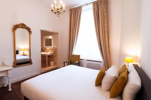 格罗宁根诗密尔本尼克豪斯酒店的卧室配有一张白色大床和镜子