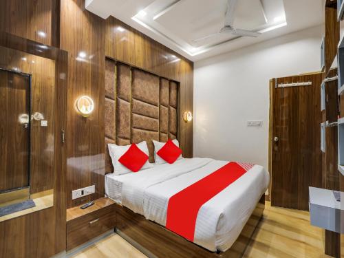 艾哈迈达巴德OYO Hotel bhanu Villa的一间卧室配有一张带红色枕头的大床