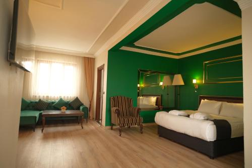 迪亚巴克尔Malabadi Hotel的一间卧室设有一张床和绿色的墙壁