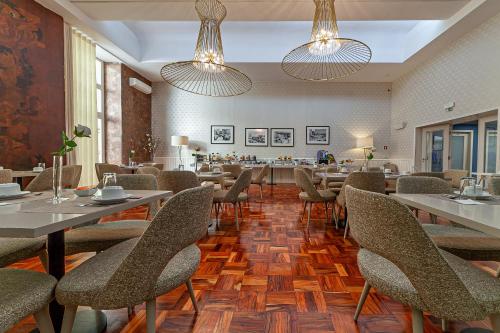 马托西纽什波尔图马尔酒店的用餐室配有桌椅和灯光