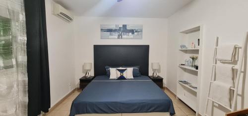 PamandziLe Madina的一间白色客房内的蓝色床卧室