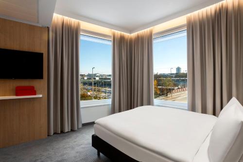 慕尼黑慕尼黑市西智选假日酒店的酒店客房设有一张床和一个大窗户