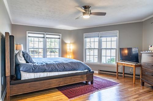 Sleeps 6- Whispering Pines Lakefront的一间卧室设有一张床、一台电视和窗户。
