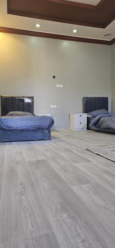 欧拉غرفة خاصة的大客房铺有木地板,配有两张床。