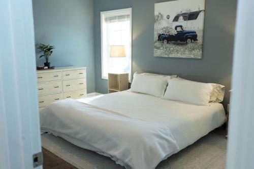 CarthageSleeps 9- In Whispering Pines的卧室配有白色的床和一辆旧车