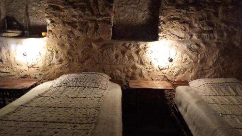 锡瓦مراقي سيوة Maraqi Siwa的一间卧室设有两张石墙床。