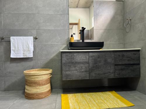佩雷贝勒Cosy Apartment in Pereybere - Season Break的浴室设有黑色水槽和黄色地毯。
