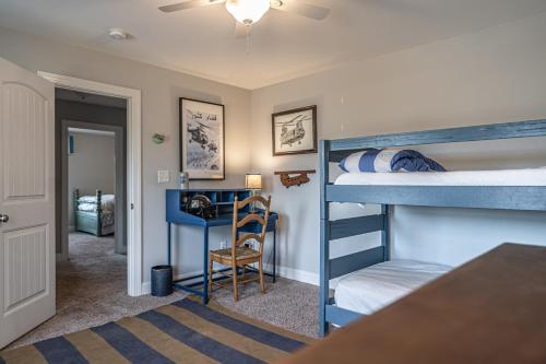 Sleeps 8- In Whispering Pines的一间卧室配有两张双层床和一张书桌