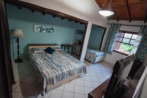 阿蒂巴亚Alameda Galu的卧室配有床、椅子和窗户。