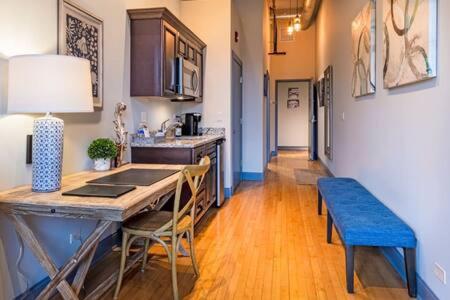 西邓迪Hip Urban Loft - Small Town Charm - 124 LOFTS #1的厨房配有桌子和蓝色长凳
