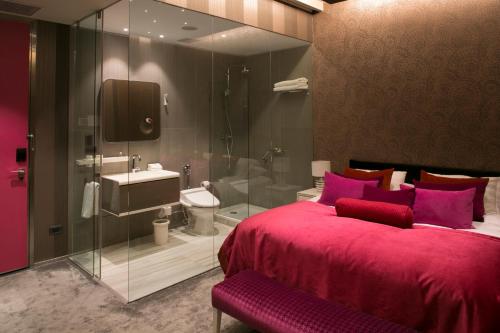 圣地亚哥The Hip Hotel Santiago的一间带红色大床的卧室和一间浴室
