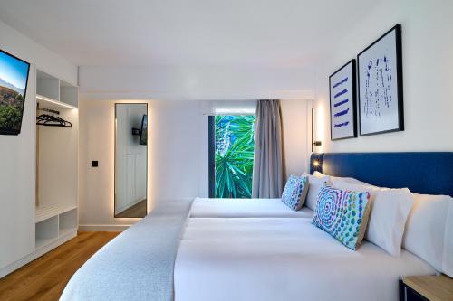格拉纳达Apartamentos Luna Suites Granada的卧室设有一张白色大床和一扇窗户。