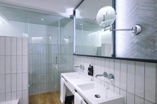 格拉纳达Apartamentos Luna Suites Granada的白色的浴室设有两个盥洗盆和镜子