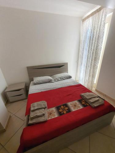 焦约萨马雷阿Appartamento Vacanza Mare Gioiosa Marea Zappardino的一间卧室配有一张带红色毯子的床和窗户。