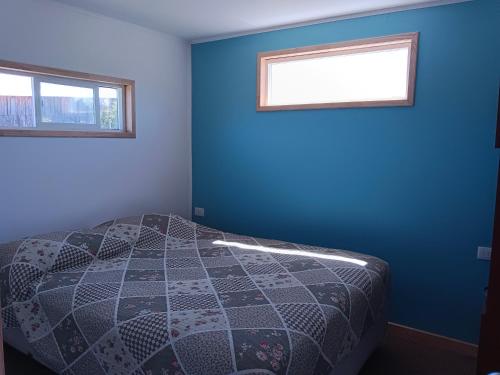 弗鲁蒂亚尔Cabaña familiar的一间卧室配有一张蓝色墙壁的床和两个窗户