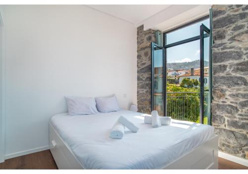 丰沙尔Casa Lanço with Spectacular View的卧室配有白色的床和大窗户