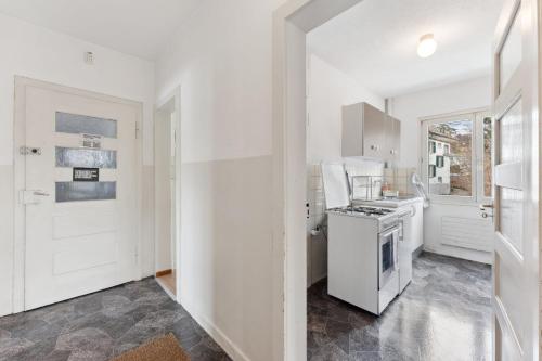 苏黎世Homey Comfort in Oerlikon的厨房配有白色橱柜和炉灶烤箱。