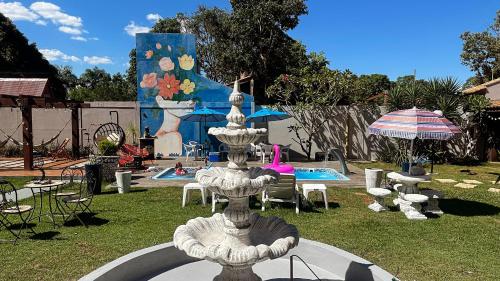 沙帕达-杜斯吉马朗伊斯Pousada Vilagio Chapada的一个带椅子和遮阳伞的庭院内的喷泉