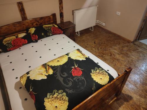 肯佩尼Cabana adi si mia cu pastravarie的一张大床,配有黑色和黄色的被子