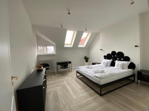 罗兹Srebrna Luxury Apartments - willa fabrykancka的一间带一张大床的卧室,位于带天窗的房间