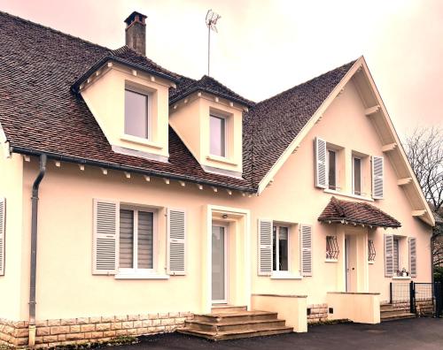 VoiteurGITE LE MAGNOLIA的黑色屋顶的白色房子
