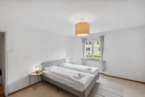 苏黎世Cozy 2 Bedroom Apartment in Zurich的白色的卧室设有床和窗户