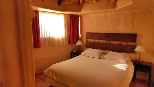 普尔马马尔卡科罗拉多洛精品露营酒店的卧室配有白色的床和窗户。