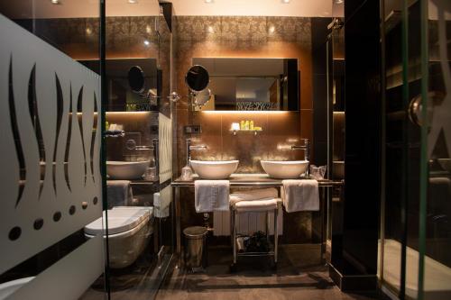 韦斯卡Hotel Sancho Abarca Petit SPA的一间带三个水槽和两个卫生间的浴室