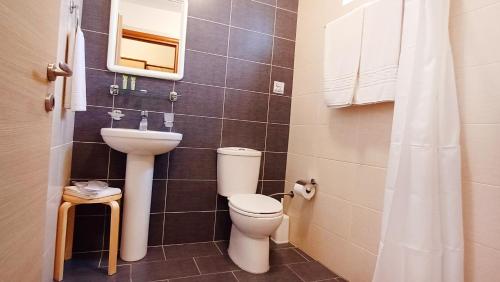 斯卡拉卡伦尼斯Arisvi All Seasons Hotel的一间带卫生间和水槽的浴室
