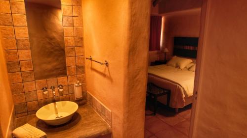 普尔马马尔卡科罗拉多洛精品露营酒店的一间带水槽的浴室和一张位于客房内的床