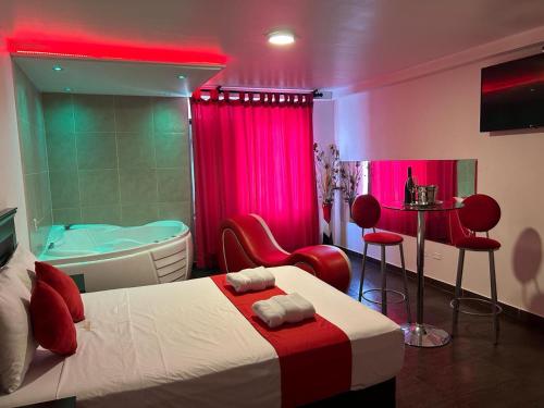 利马GOLDEN DREAM´S的一间带浴缸的卧室和一张带红色椅子的床