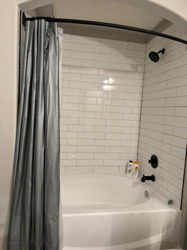 陶森Towson Elite Apartment的浴室内设有带浴帘的白色浴缸