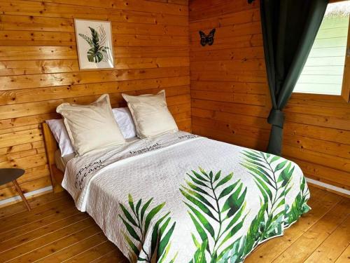 Chalets Chomoni的木制客房内的一间卧室,配有一张床