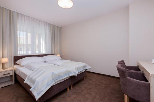 波别罗沃Apartamenty Angela的一间卧室配有一张床、一张书桌和一个窗户。