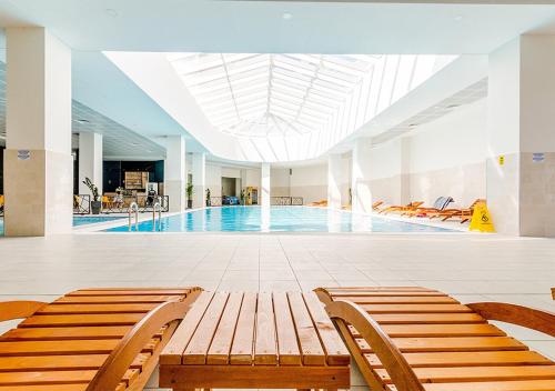 斯科普里Horizon Grey Apartment & Spa的一座带两个长椅的游泳池