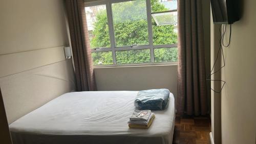 库里提巴Vicz Hotel的窗户客房内的一张床位