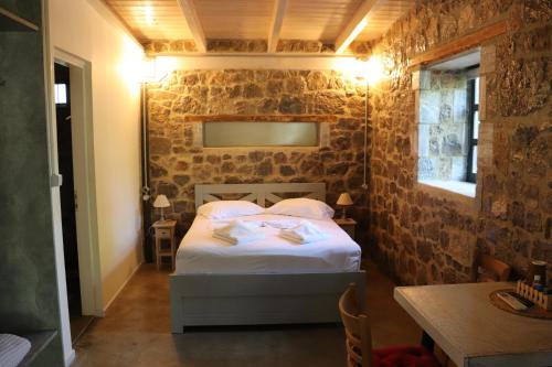 OrchomenósFARMAHOUSE的卧室配有砖墙内的床铺
