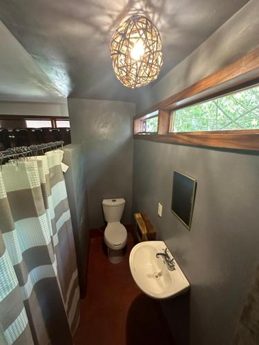 马祖特Casa AVA的一间带水槽、卫生间和吊灯的浴室