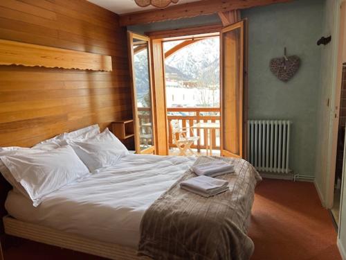 皮伊圣万桑Hôtel Restaurant La Pendine的一间卧室设有一张床和一个大窗户